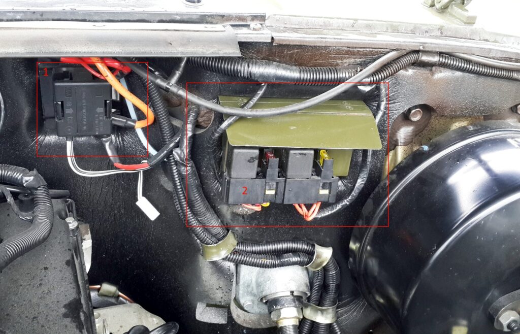 Umístění pojistkové skříňky v motorovém prostoru vozidla.